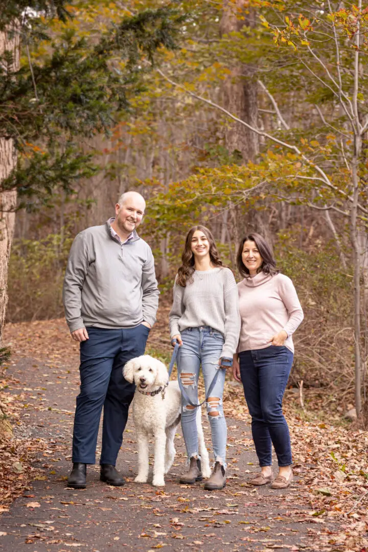 A family posing for a picture with their dog.