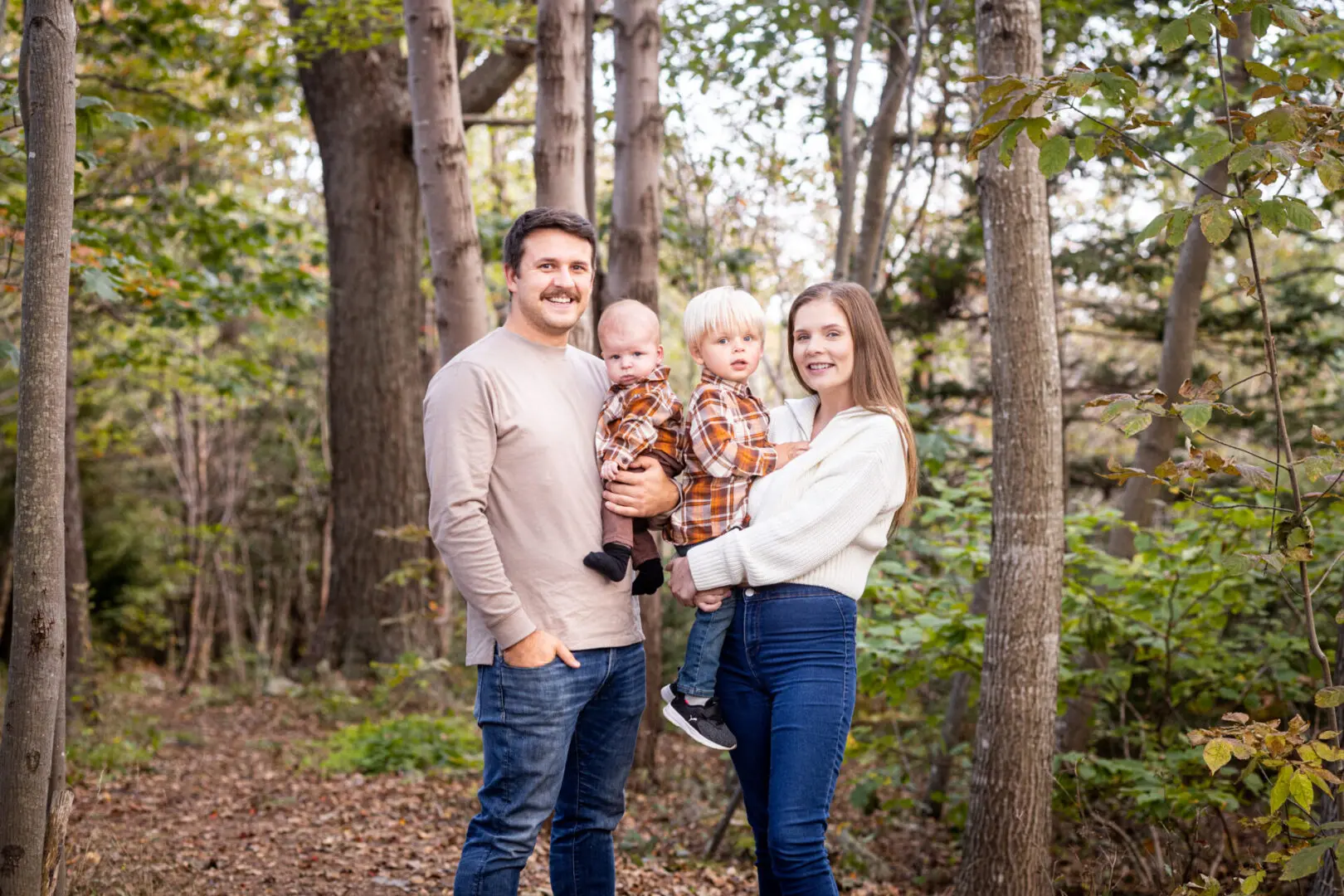 A family posing for a picture in the woods