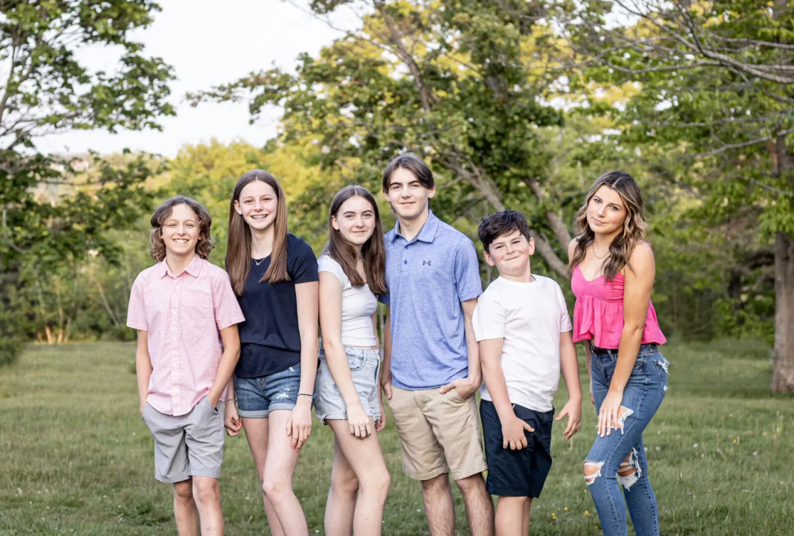 A group of young people standing in the grass.