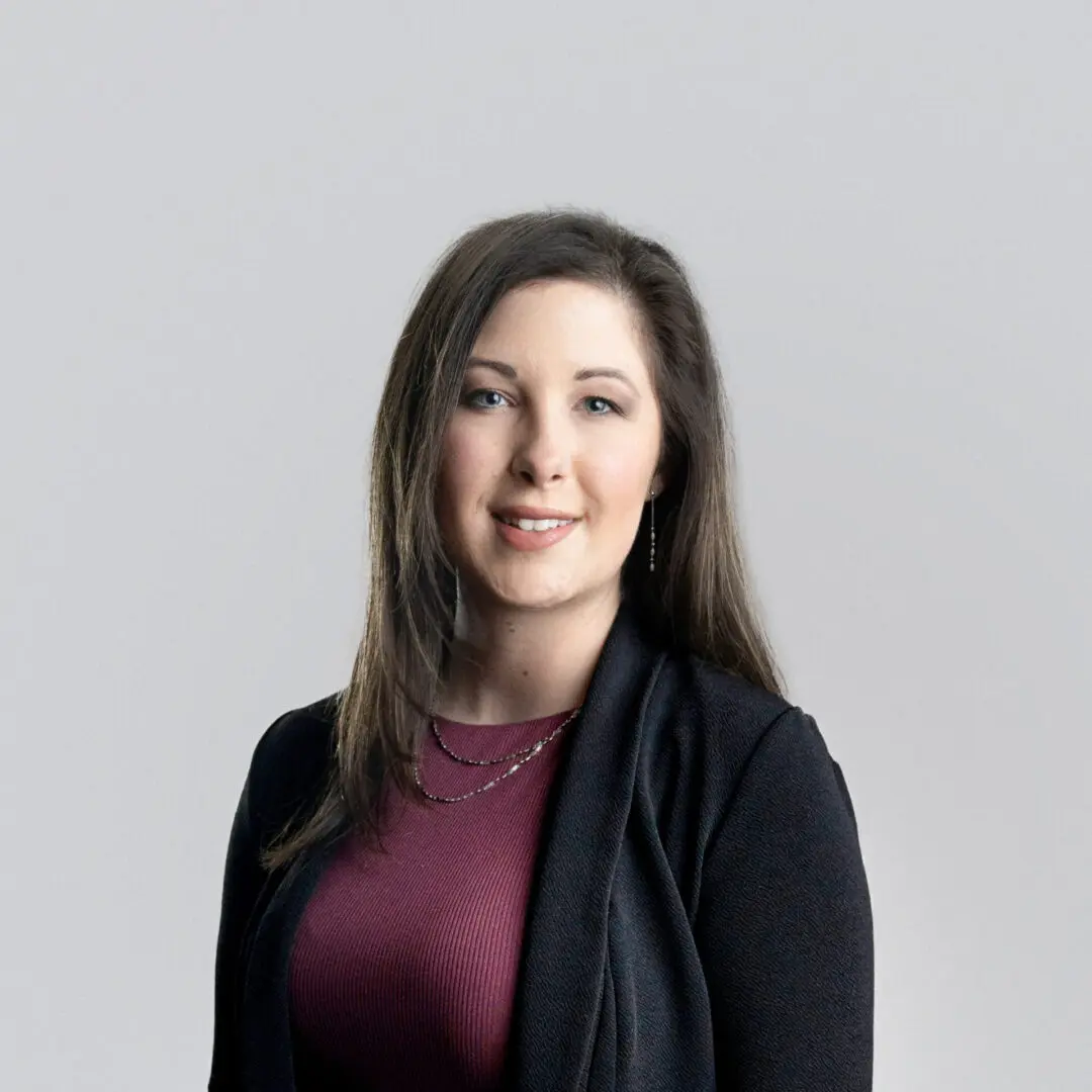 A woman in a black jacket and red shirt