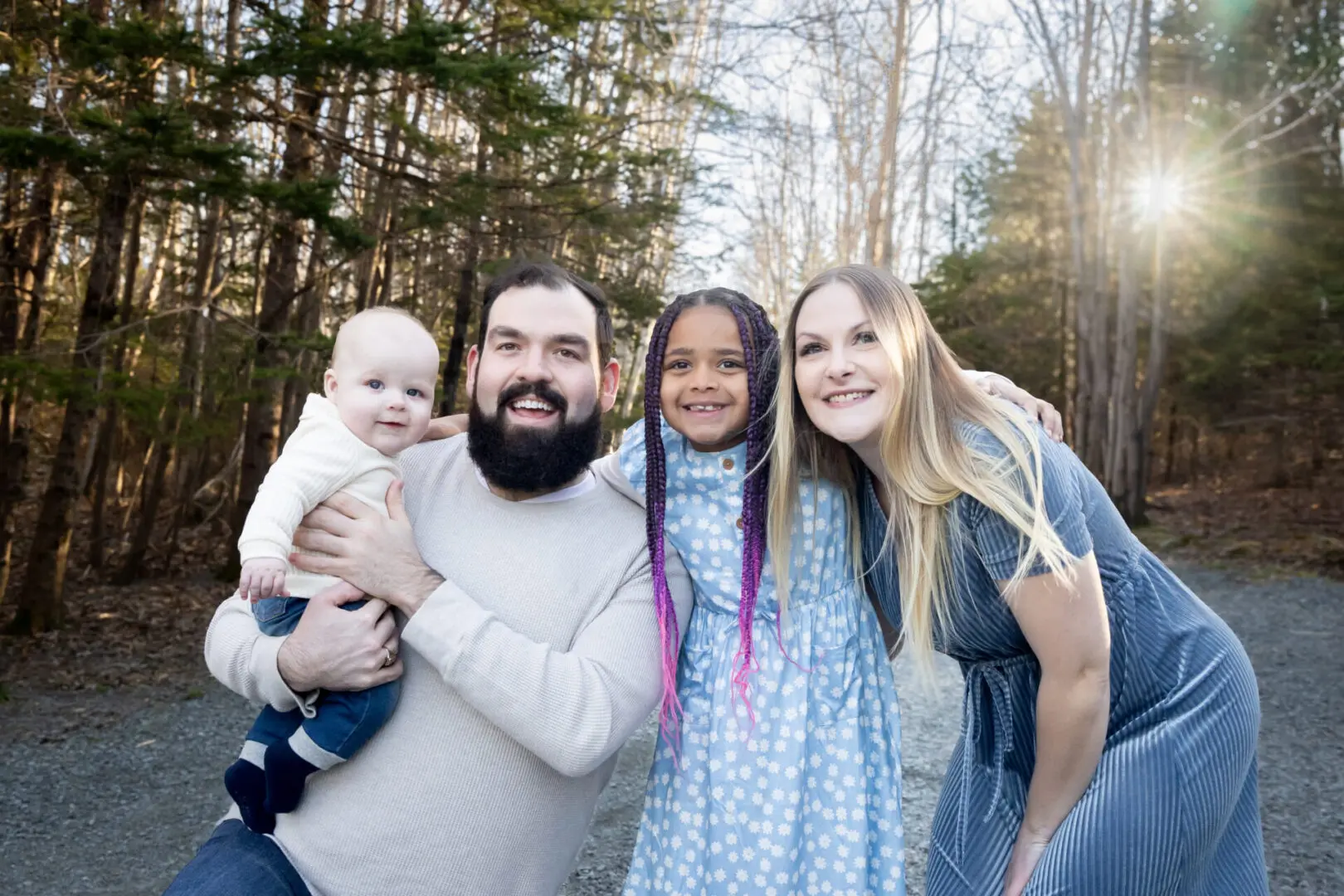 A family posing for a picture in the woods.