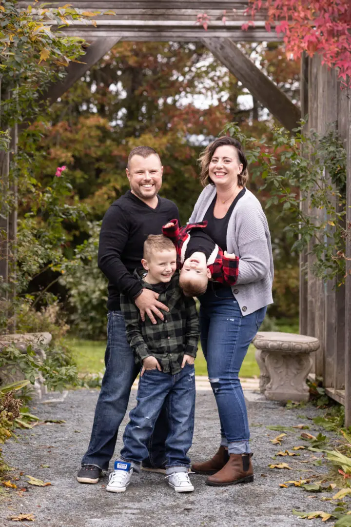 A family posing for the camera in front of trees.