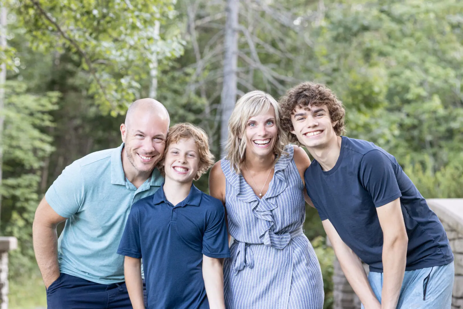 A family posing for a picture in the woods.