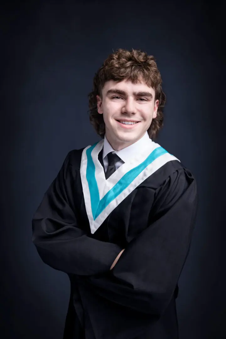 A young man in graduation attire posing for the camera.