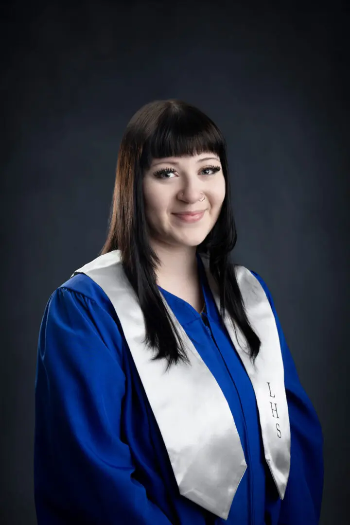 A woman in graduation gown and long hair.