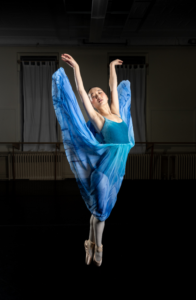 A woman in blue dress dancing on stage.