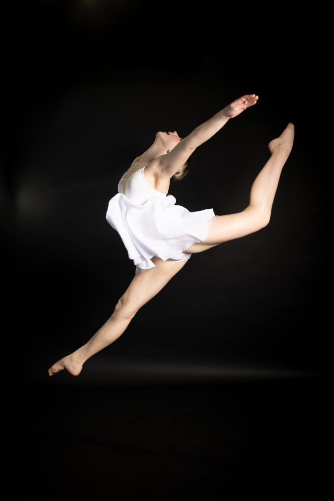 A woman in white leaping into the air.