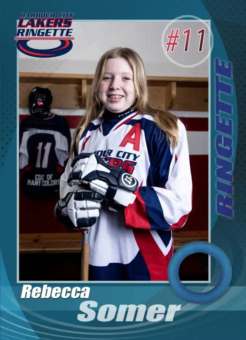 A girl in hockey gear posing for the camera.