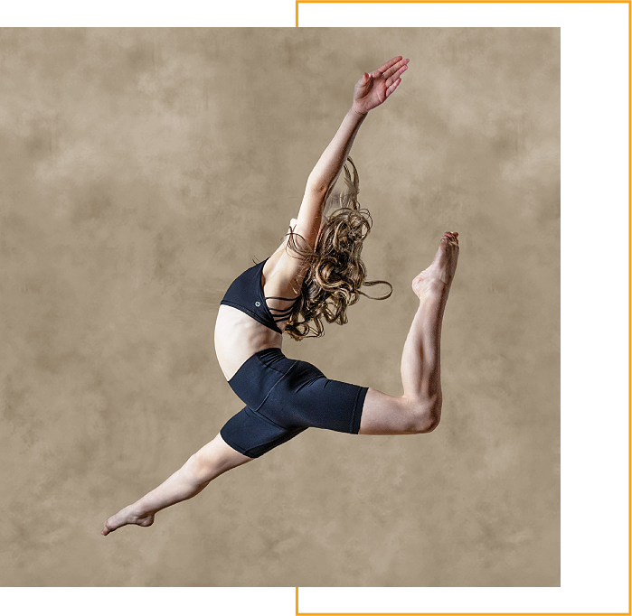 A woman jumping in the air with her arms outstretched.